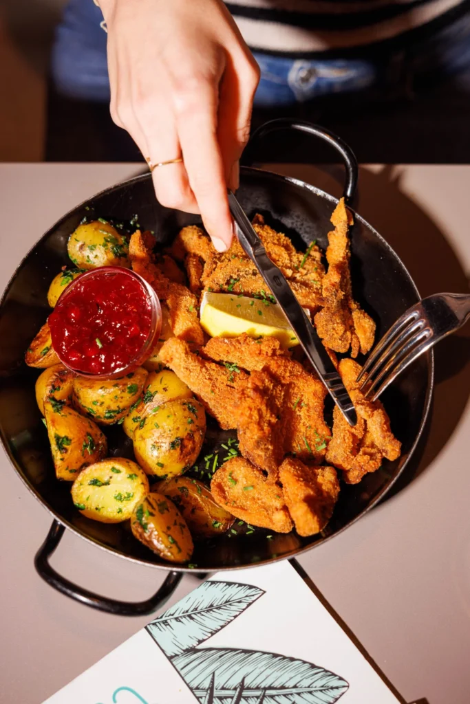 Pan with crispy fried pieces, roasted potatoes and dip served at Let's Be Frank Vienna