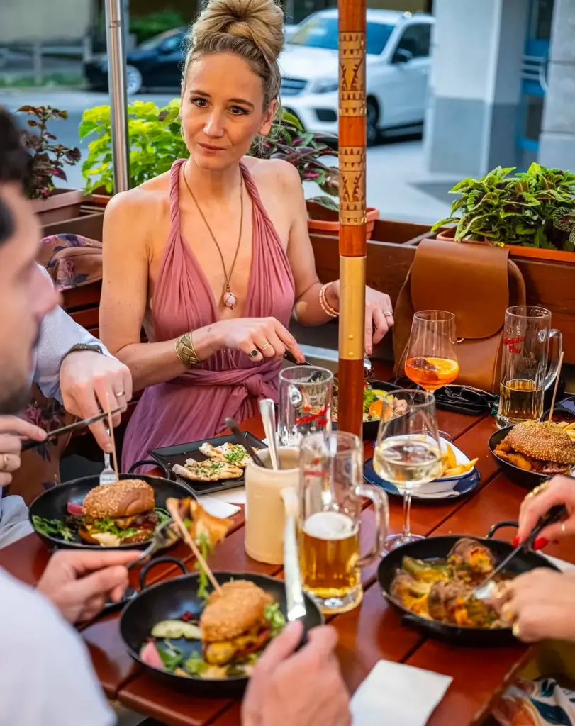 Woman at a table with several dishes from Frank's 3-Course Menu in Vienna