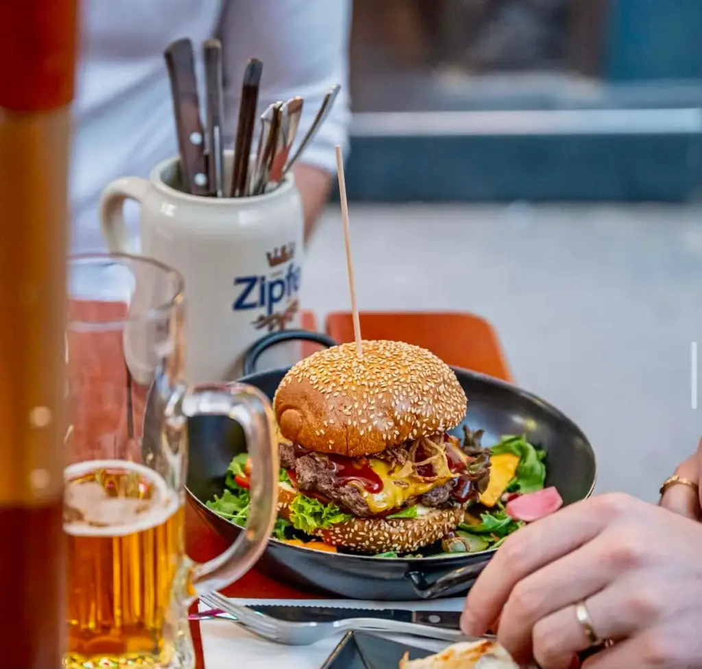 Burger with fries and a beer on the table at the Wednesday Burger Special