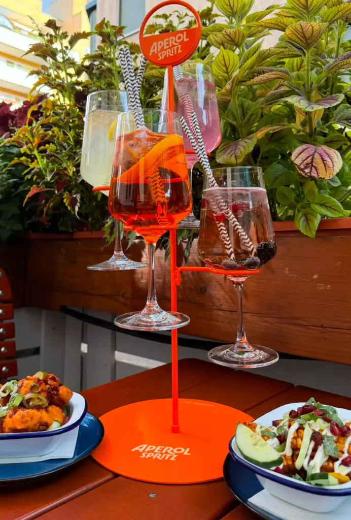 Aperol Spritz and cocktails on a table with snacks at Frank's Apéro Hour in Vienna