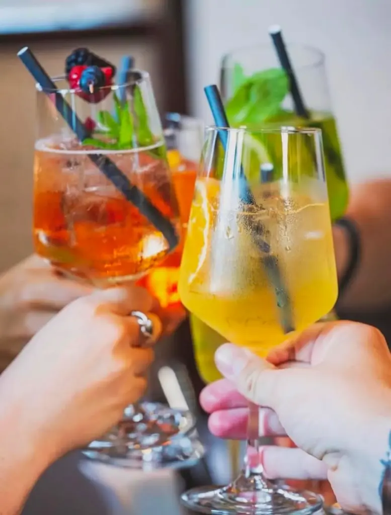 Friends toasting with Spritz and cocktails during Apéro Hour at Let's Be Frank